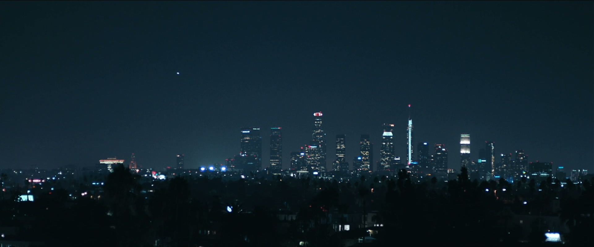 A city skyline at night, seen from the hills.